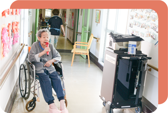 介護老人保健施設内のカラオケ機械で歌を歌う高齢女性
